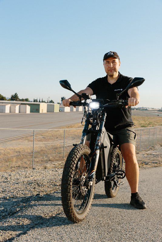 Daniel Tonkopiy with a Delfast e-bike at an airfield in Los Angeles